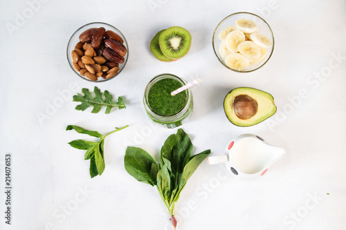 Glass of green vegetable smoothie on white background from top view