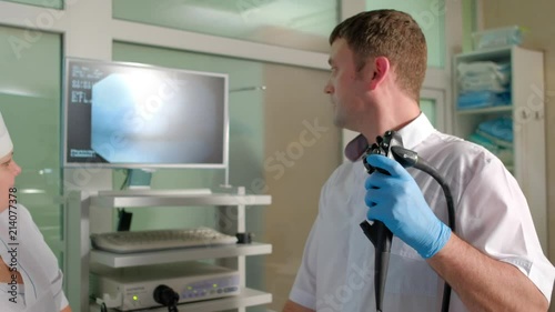 The doctor and the nurse do a colonoscopy through the mouth of the patient photo