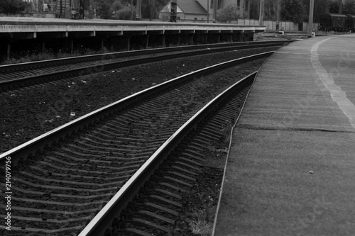 Railroad tracks for the train. In the area of the pen. Brilliant rails go nowhere. Black and white photo of a railway empty platform.