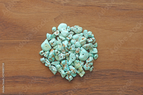 Turquoise stones on a background of natural wood black walnut. Blue color stone. Collection of minerals and natural stones. Heap of stones photo