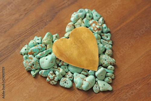 Turquoise stones on a background of natural wood black walnut. Blue color stone. Collection of minerals and natural stones. Heart made of natural stones. A beautiful heart photo