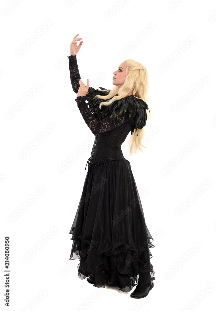 full length portrait of blonde girl wearing corset and long black gown. isolated on white studio background, full length portrait of blonde girl wearing corset and long black gown. isolated on white studio background,