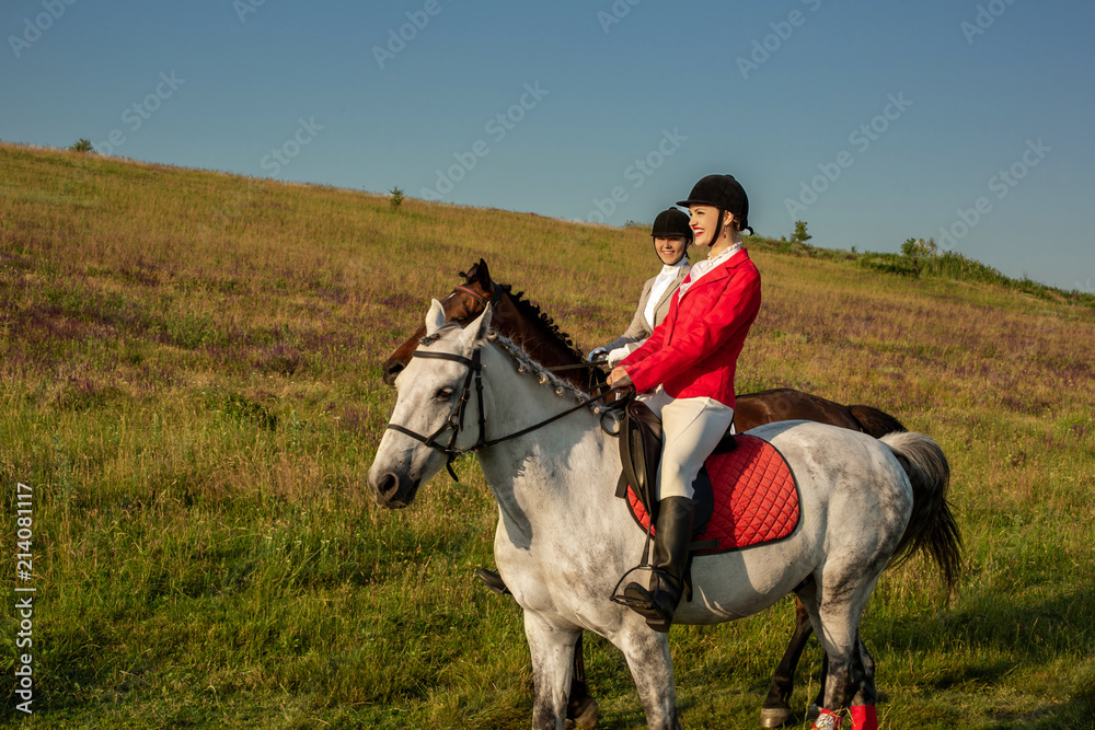 Two young women riding horse in park. Horse walk in summer Two young women riding horse in park. Horse walk in summer