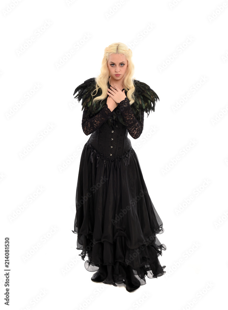 full length portrait of blonde girl wearing corset and long black gown. isolated on white studio background, full length portrait of blonde girl wearing corset and long black gown. isolated on white studio background,