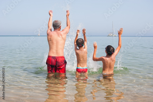 Family with three people are splashing in the sea