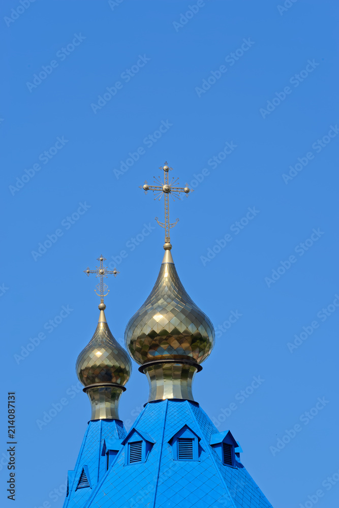 Blue roofs of russian orthodox church against clear blue sky. Cathedral of Our Lady of Kazan in Komsomolsk-on-Amur in Russia
