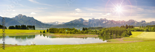 Panorama Landschaft in Bayern mit Alpen im Allgäu und Spiegelung im Forggensee