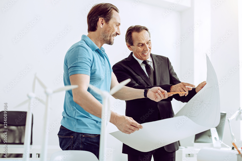 Explanation. Qualified calm friendly engineer giving a detailed explanation to his clever cheerful client Explanation. Qualified calm friendly engineer giving a detailed explanation to his clever cheerful client