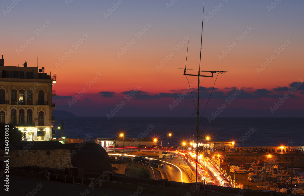 Night city Heraklion and embankment with night illumination and sunset (Greece)