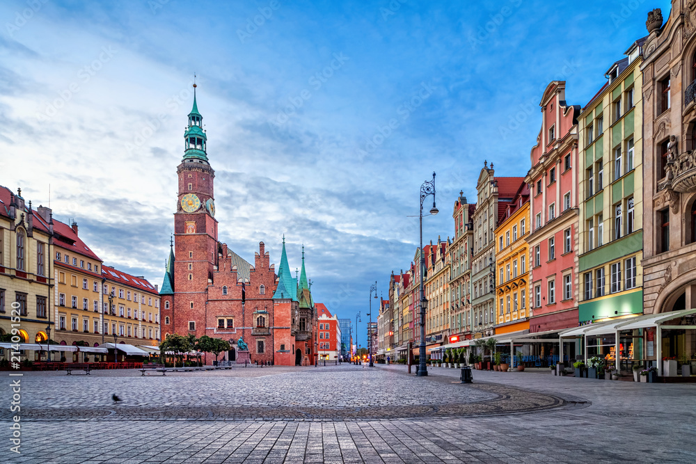 Fototapeta premium Kolorowe domy i zabytkowy budynek ratusza na placu Rynek o zmierzchu we Wrocławiu