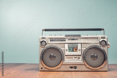 Retro outdated portable stereo boombox radio receiver with cassette recorder from circa late 70s front mint green wall background. Listening music concept. Vintage old style filtered photo