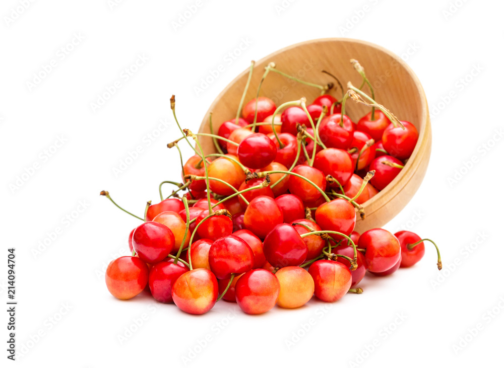 Cherries scattered from wooden bowl on white. Cherries scattered from wooden bowl on white.