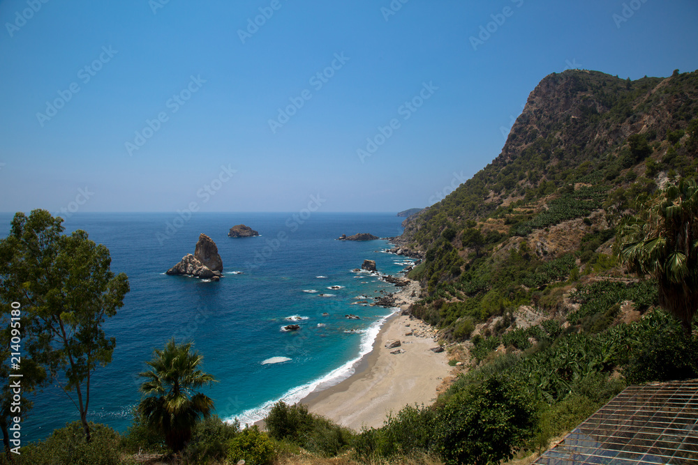 Sand, wild beach coast with sea or ocean and mountain rocks