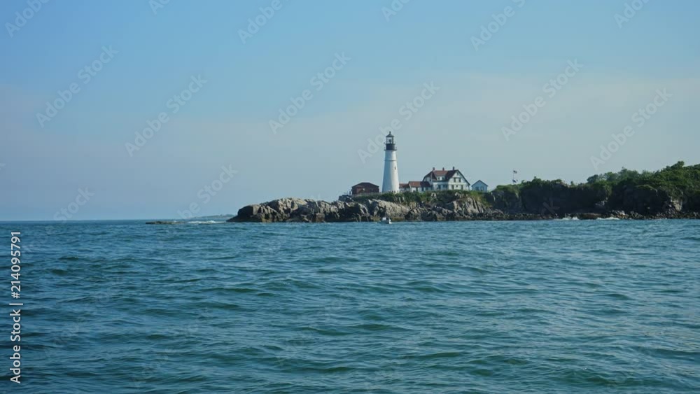 A daytime view of the Portland Head Lighthouse and surrounding rocky cliffs near downtown Portland, Maine. As seen from a boat in the harbor. Shot at 48fps slow motion. A daytime view of the Portland Head Lighthouse and surrounding rocky cliffs near downtown Portland, Maine. As seen from a boat in the harbor. Shot at 48fps slow motion.