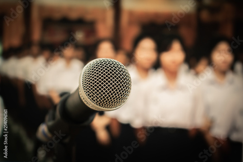 Microphone on abstract blurred of front podium and speech in seminar room or speaking conference hall light, Event meeting bokeh background, vintage tone