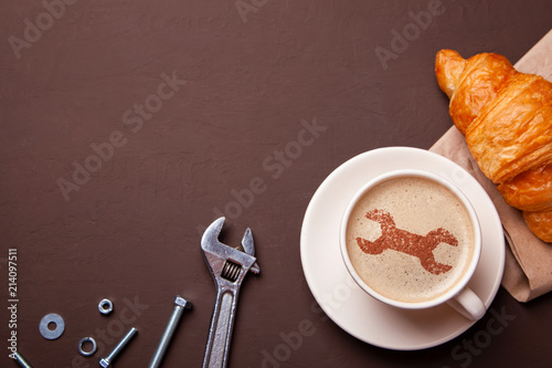 Cup of coffee with  wrench on the foam. I like a coffee break with  croissant. Repair service concept. Technical support