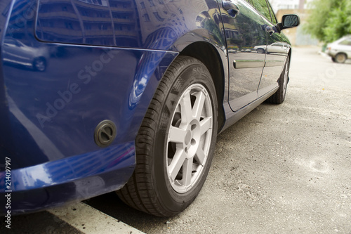 Close up view with automobile. Front car wheel on the asphalt road. Tyre, tire.