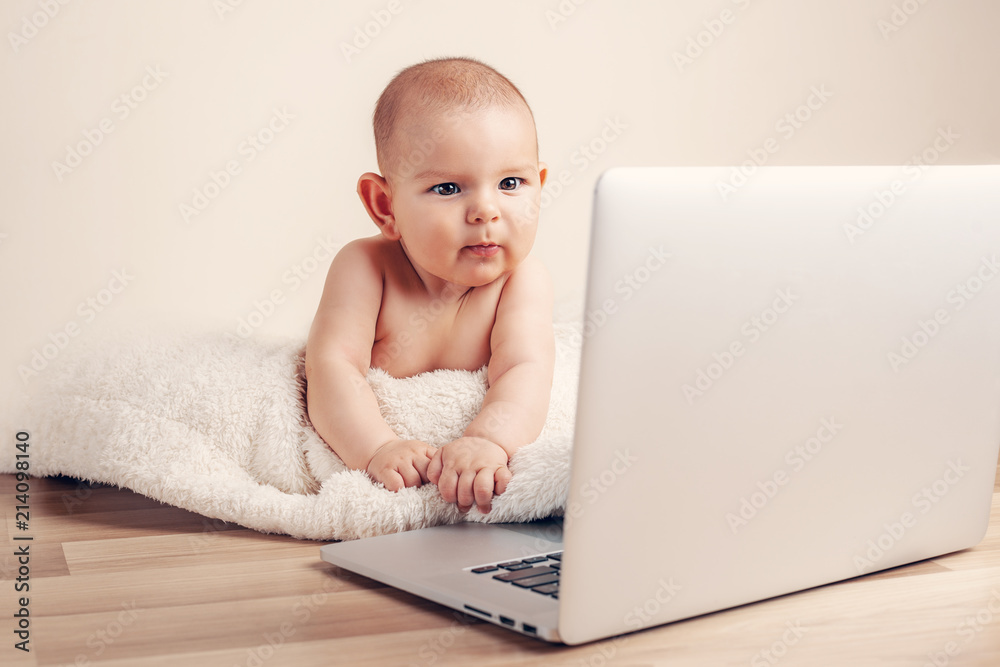 Small baby infant working playing learning on the laptop wireless serious face expression Small baby infant working playing learning on the laptop wireless serious face expression