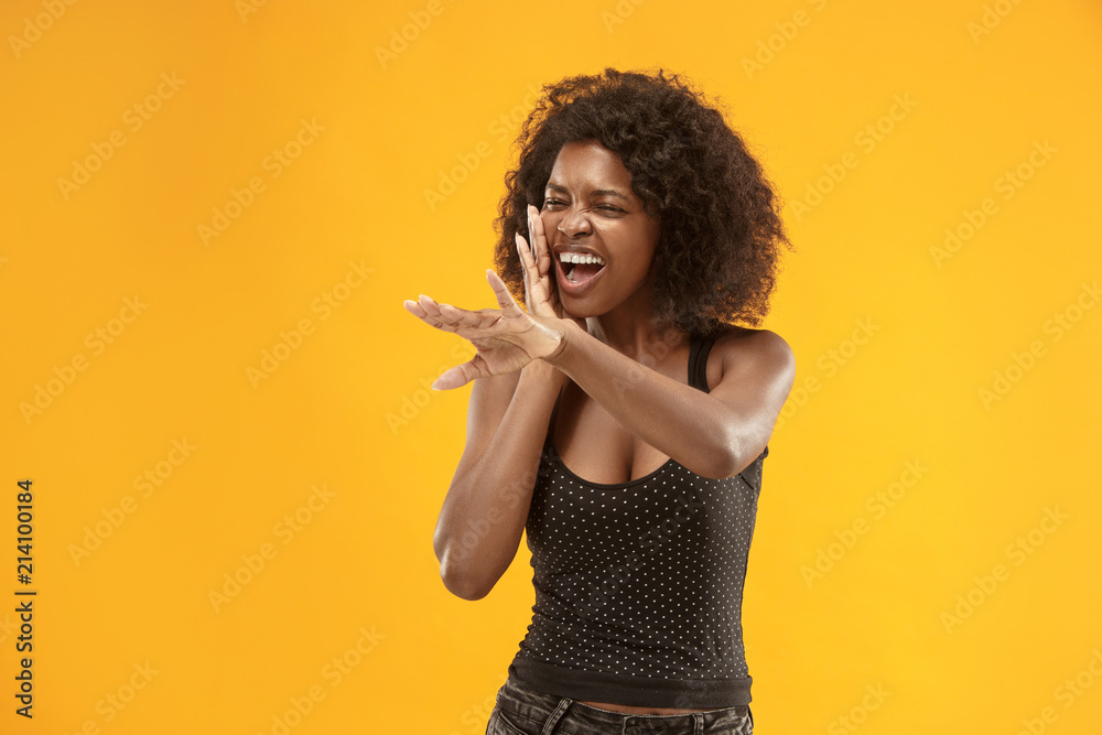 Fototapeta premium Isolated on red young casual afro woman shouting at studio
