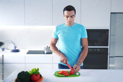 Professional robot. Calm concentrated busy humanoid helping people and cooking a salad in the modern kitchen