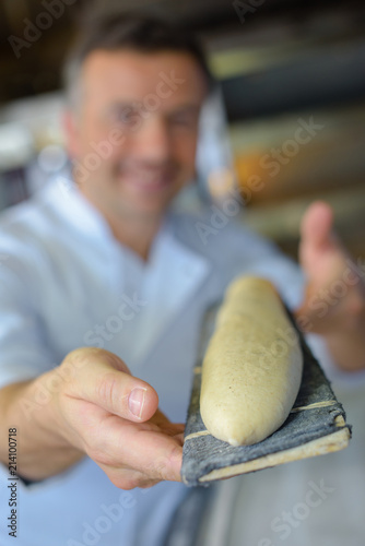 proud baker baking baguette bread in his kitchen