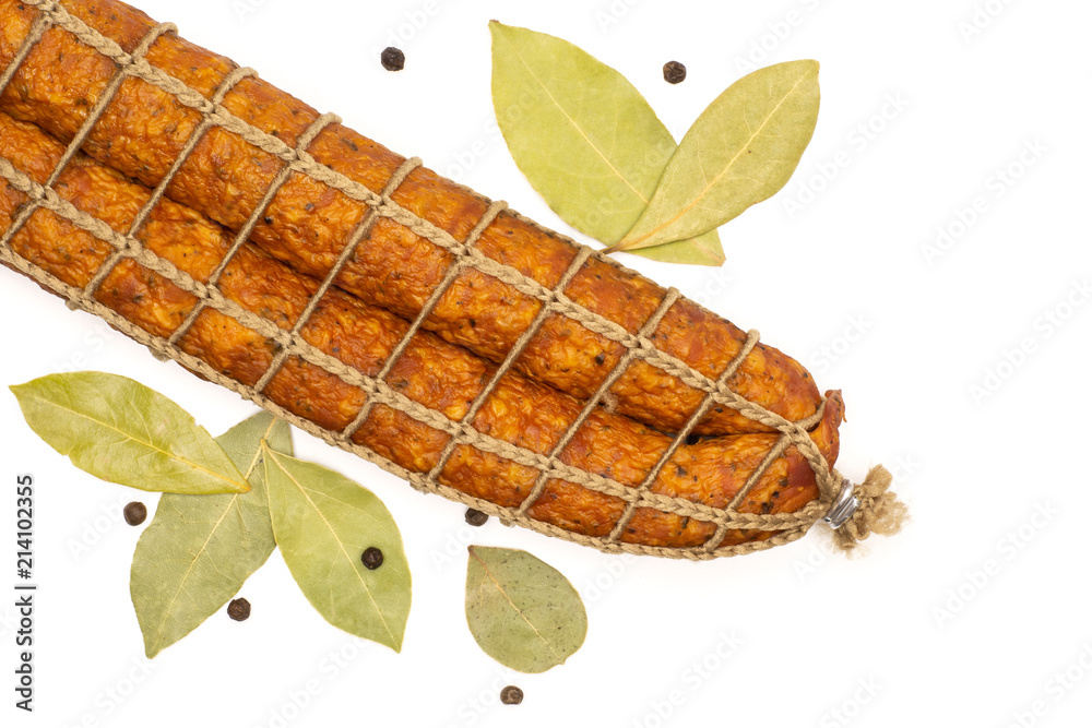 Group of two whole dry smoked ham sausage with dry bay laurel leaves and black pepper flatlay isolated on white Group of two whole dry smoked ham sausage with dry bay laurel leaves and black pepper flatlay isolated on white