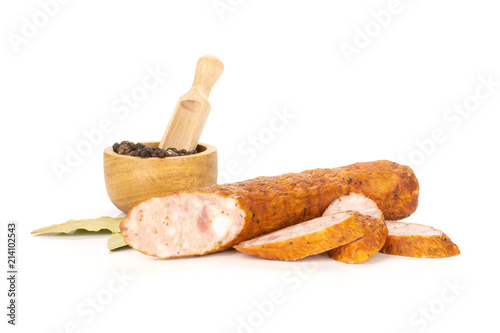 Group of one half three slices of dry smoked ham sausage with black pepper in a wooden bowl and bay leaves isolated on white