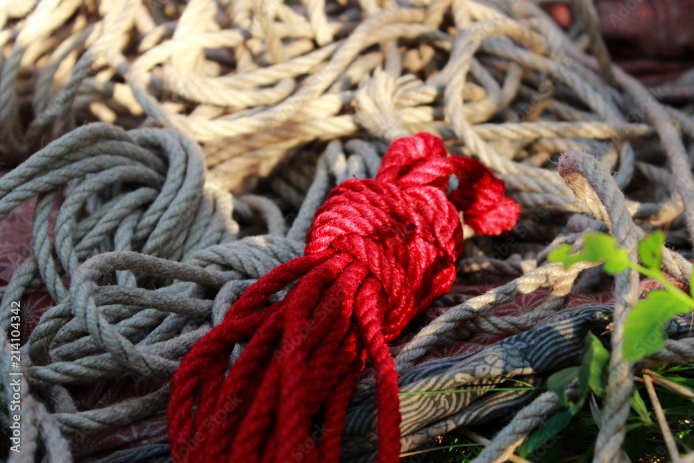 Texture of jute ropes used in shibari, Japanese bondage technique. Many skeins and loose ropes for shibari and bondage. One red rope