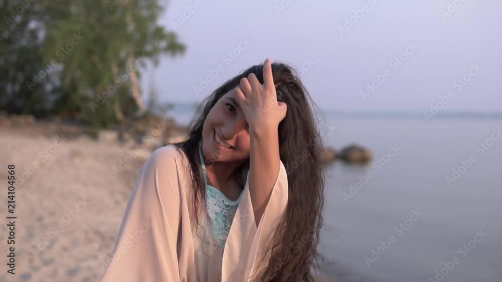 A beautiful girl in a beach tunic turns around herself and smiles. slow motion. A beautiful girl in a beach tunic turns around herself and smiles. slow motion.