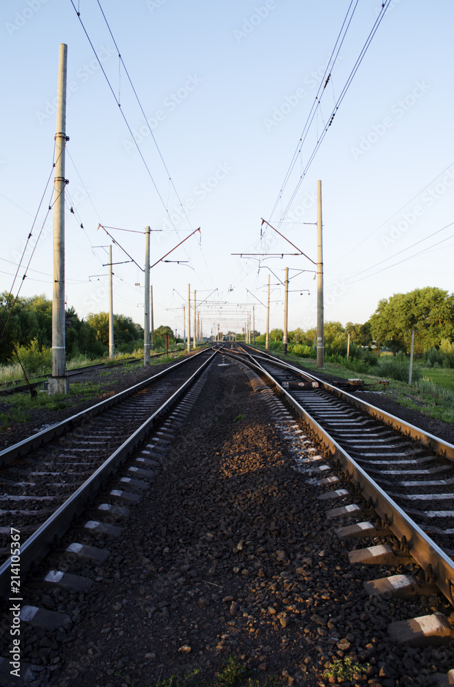 Electrified double-track railway at sunset