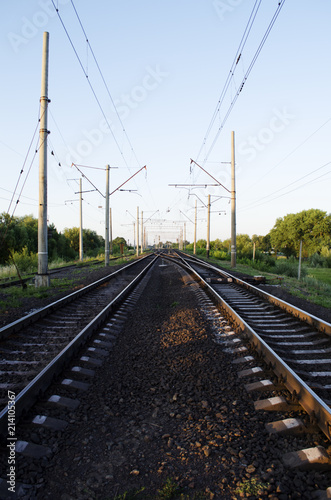 Electrified double-track railway at sunset