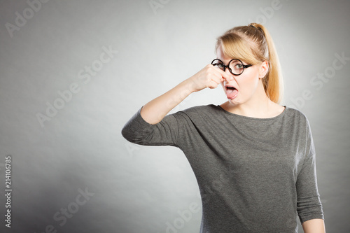 Фотография Nerdy girl holding nose.