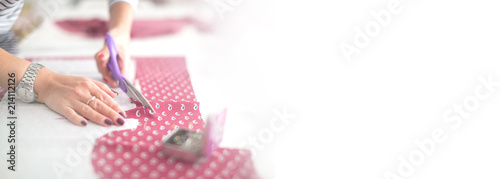 Tailor measuring textile material. young woman seamstress making pattern on fabric with tailors chalk. Girl working with a sewing pattern. Hobby sewing as a small business concept.