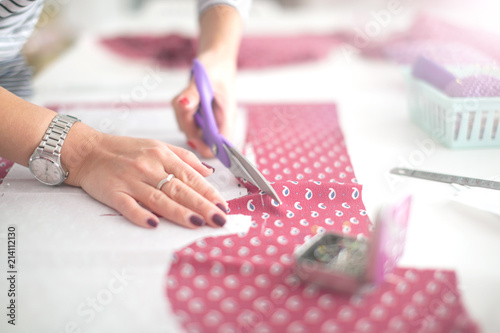 Tailor measuring textile material. young woman seamstress making pattern on fabric with tailors chalk. Girl working with a sewing pattern. Hobby sewing as a small business concept.