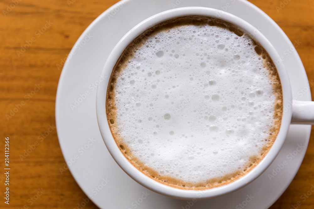 Cappuccino cup on wooden table close-up Cappuccino cup on wooden table close-up