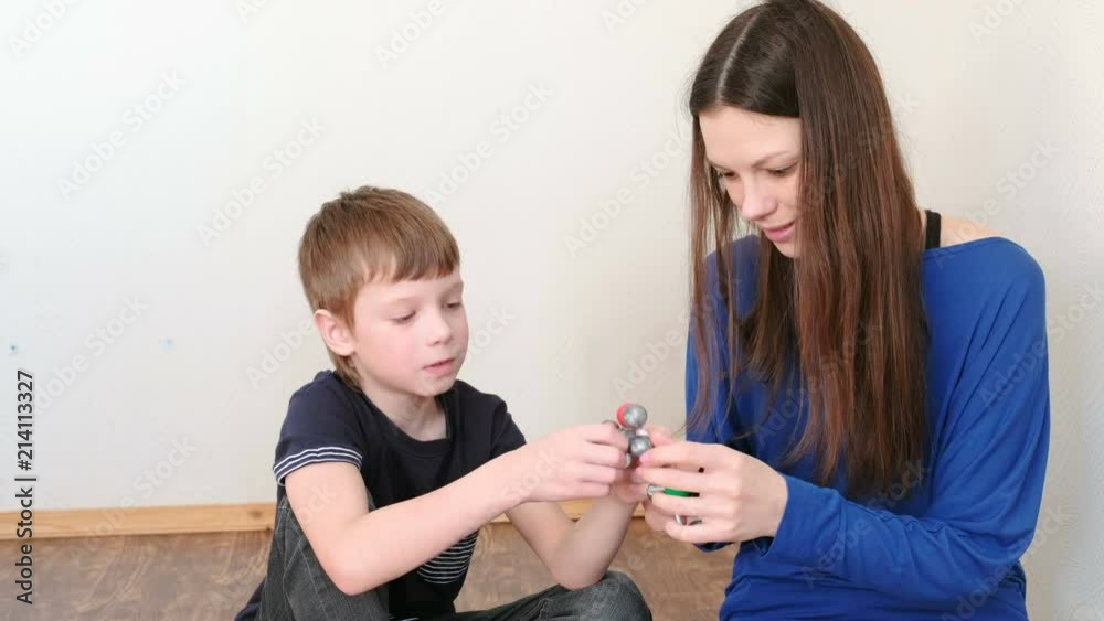 Mom with son building molecule models of colored plastic construction set. Mom with son building molecule models of colored plastic construction set.