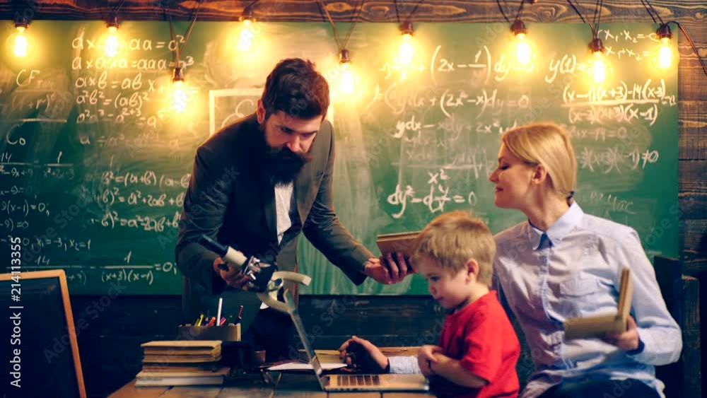 Two teachers are interested in learning a boy. Learning concept. School children in uniform. Teacher in classroom. Teacher and student. Back to school.