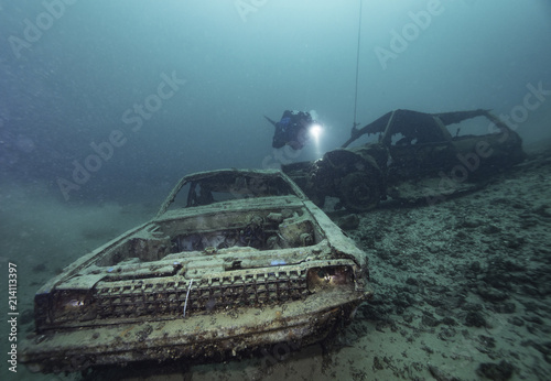 Car wrecks under water with scuba diver in a lake underwater, Germany