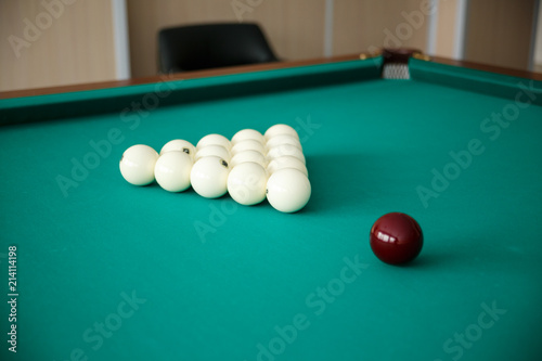 Cue ball for Russian billiards on the table. White billiard balls on the background.