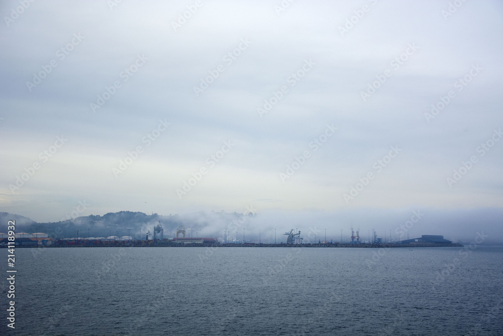 Photo of a port with fog, sea and sky