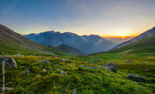 majestic panoramic summer sunset in a mountainous green valley © serikbaib