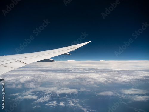 View from airplane window with blue sky and white clouds, background for travel holiday trip, Aircraft on the sky.