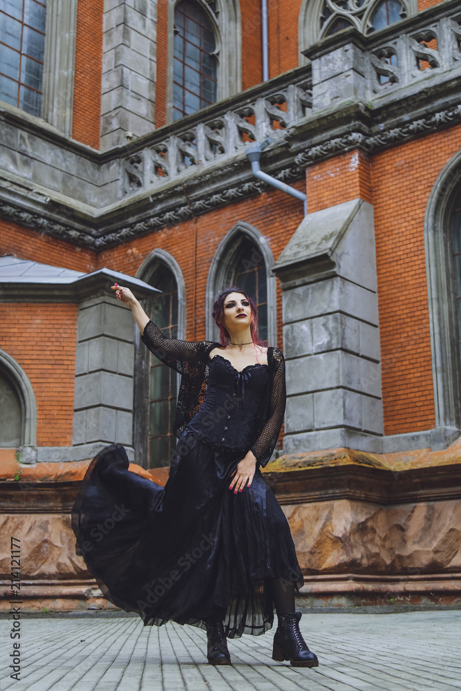 Young brunette girl in gothic style on a background architecture