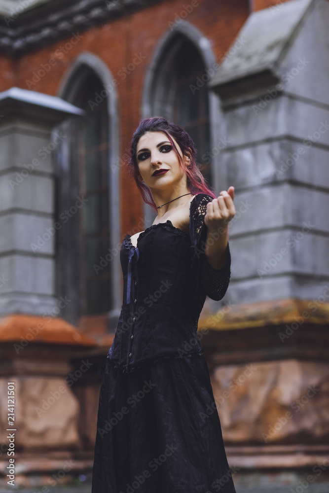 Young brunette girl in gothic style on a background architecture