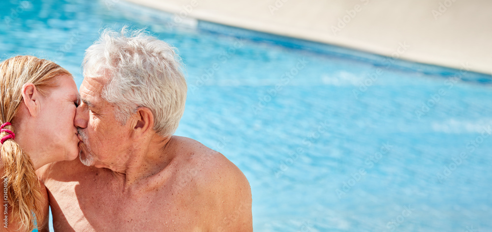 Fototapeta premium Senioren Paar beim Küssen im Hotel Pool