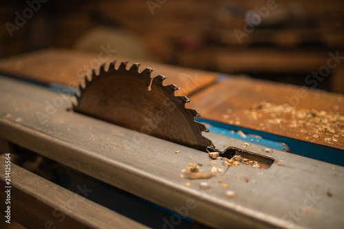 Saws details of furniture with a circular saw. Tinted image. close up. circular saw for cutting wood. workshop, wooden sawdust flying in the sides. to plan a tree.