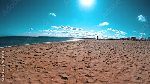 Summer day at beach, people relaxing, walking, seagulls flying, young father take care of his child