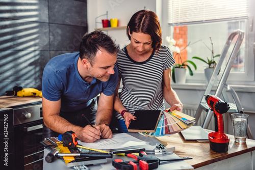 Couple looking at color swatch during kitchen renovation