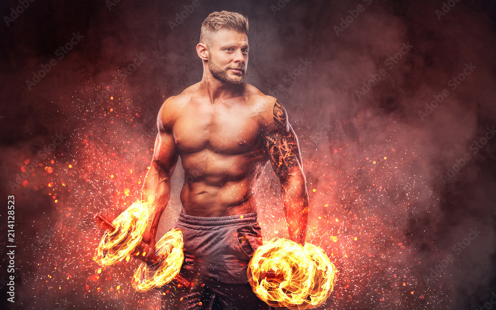 Handsome shirtless tattooed bodybuilder with stylish haircut and beard,  wearing sports shorts, posing in a studio. Fire art concept. Stock Photo |  Adobe Stock