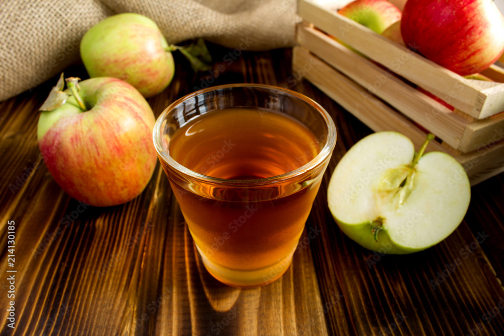 Apple juice in the glass on the brown wooden background Apple juice in the glass on the brown wooden background